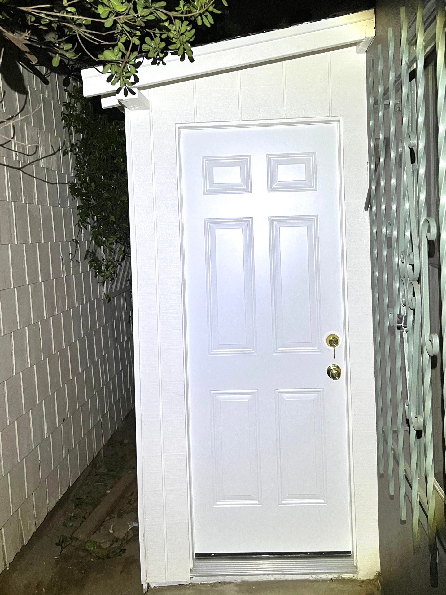 Finished white side-yard shed with a solid entry door